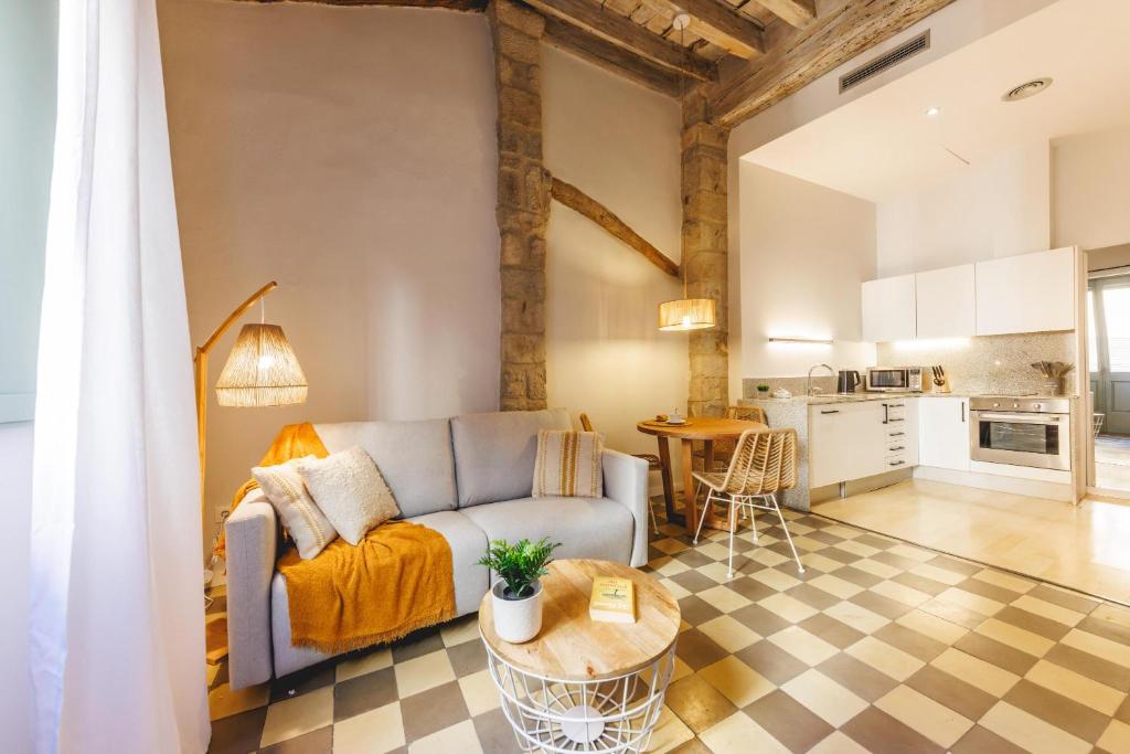 a living room with a couch and a table at Bravissimo Calderers La Lleona, heart of the Barri Vell in Girona