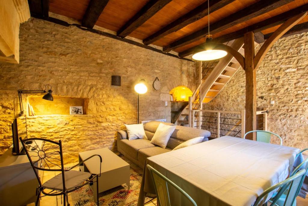 un soggiorno con un tavolo e un divano di La pomponnaise a Saint-Pompont