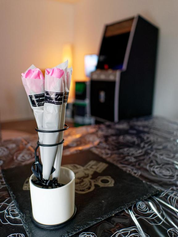 un vase rempli de fleurs roses sur une table dans l'établissement Gîte de la Fontaine, à Rocourt-Saint-Martin