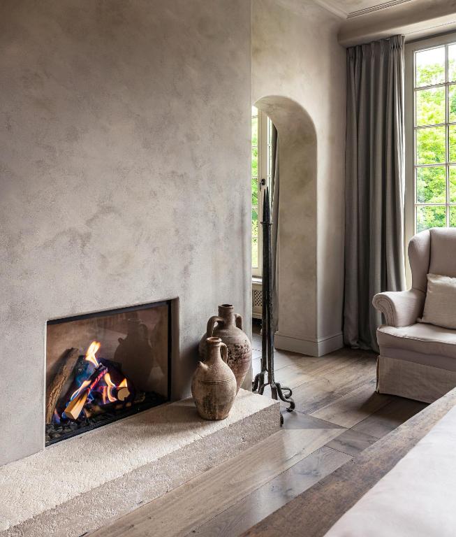 a living room with a fireplace and a chair at The Notary in Bruges
