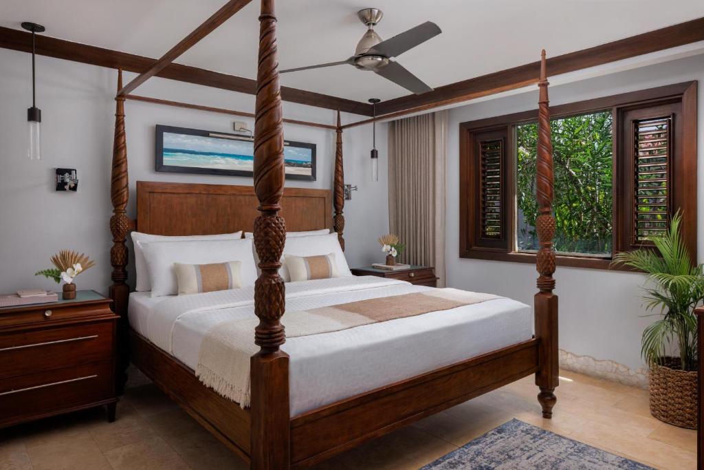 a bedroom with a four poster bed and windows at Sandals Barbados All Inclusive - Couples Only in Christ Church