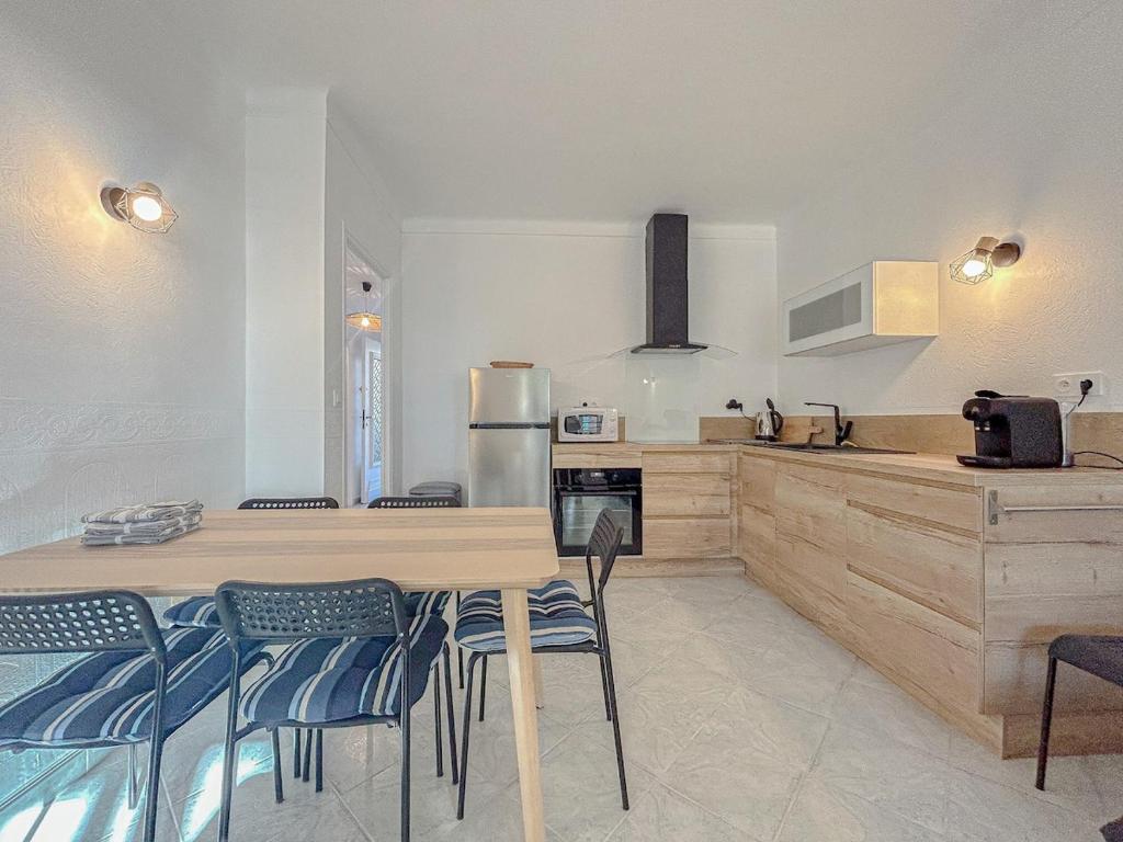 une cuisine avec une table et des chaises dans une cuisine dans l'établissement Face à la mer, T3 avec terrasse et parking privé, à Fréjus