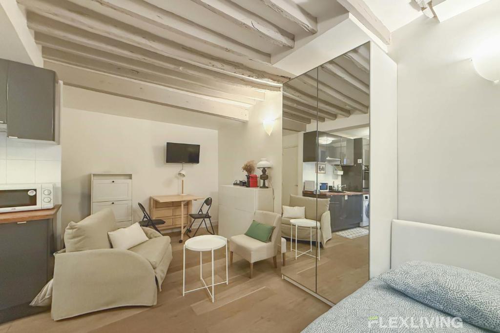 une chambre avec un lit et un salon dans l'établissement Flexliving - Studio - Duvivier, à Paris