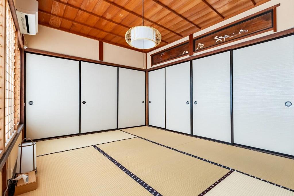 an empty room with white cabinets and a ceiling at Manabi-stay Matsue 駅近伊勢宮町どこに行くにも最高に便利な古民家一棟貸切ホテル in Matsue