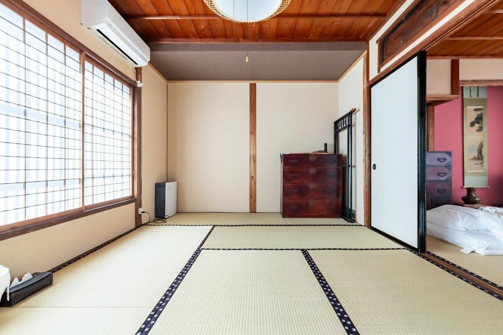 an empty room with a door open to a bedroom at Manabi-stay Matsue 駅近伊勢宮町どこに行くにも最高に便利な古民家一棟貸切ホテル in Matsue