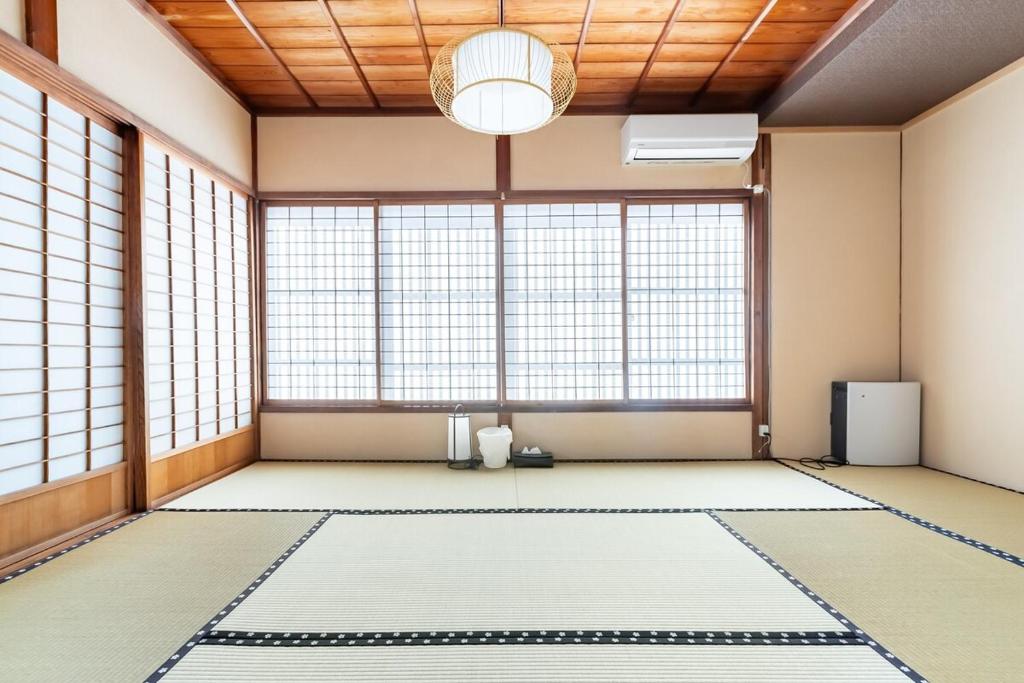 a room with a large window with a large rug at Manabi-stay Matsue 駅近伊勢宮町どこに行くにも最高に便利な古民家一棟貸切ホテル in Matsue