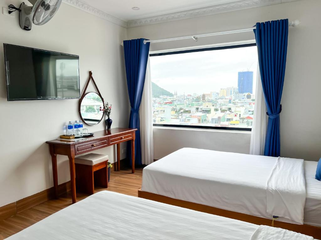a hotel room with two beds and a window at HaTa Hotel in Quy Nhon