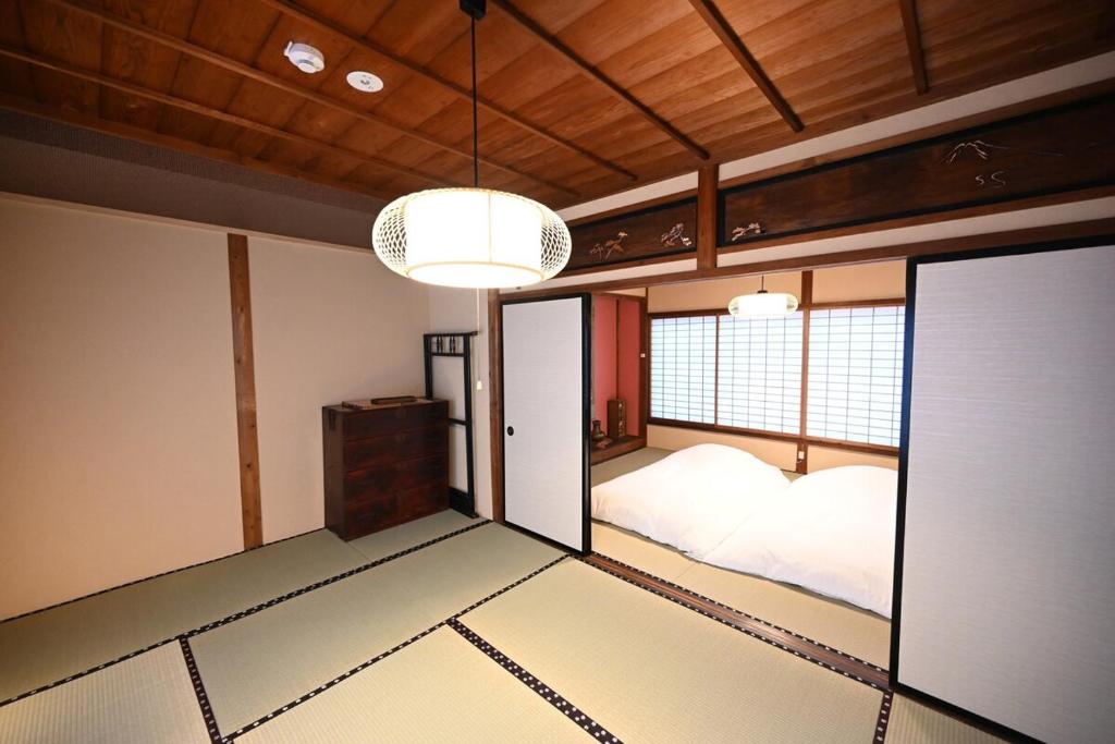 a room with a bed and a chandelier at Manabi-stay Matsue 駅近伊勢宮町どこに行くにも最高に便利な古民家一棟貸切ホテル in Matsue