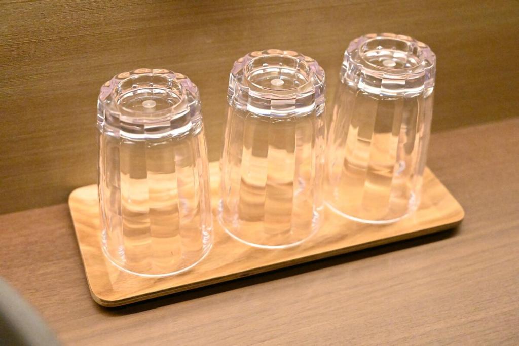 two clear glass containers sitting on a wooden cutting board at Manabi-stay Matsue 駅近伊勢宮町どこに行くにも最高に便利な古民家一棟貸切ホテル in Matsue