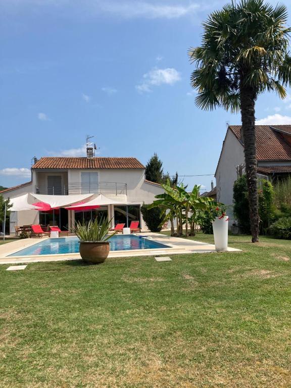 une maison avec un palmier et une piscine dans l'établissement Maison de vacances avec piscine à 5 minutes de Périgueux, à Trélissac