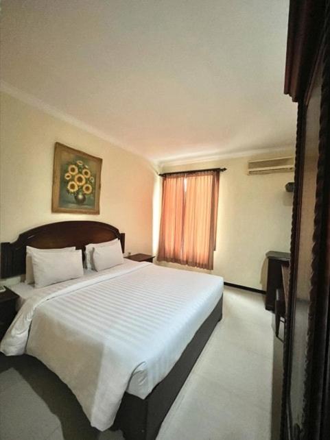 Postel nebo postele na pokoji v ubytování Tuwuh Hotel at Kayutangan