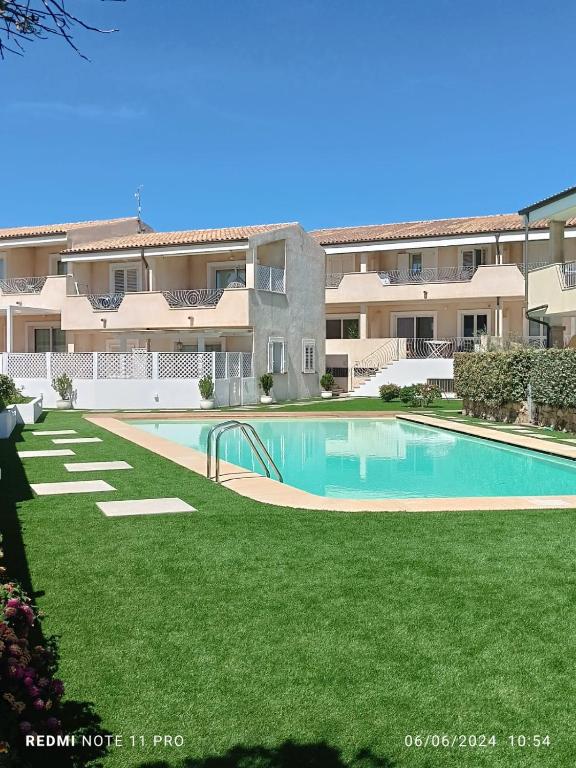 a swimming pool in front of a large apartment building at Il Gioiello a Palau in Palau