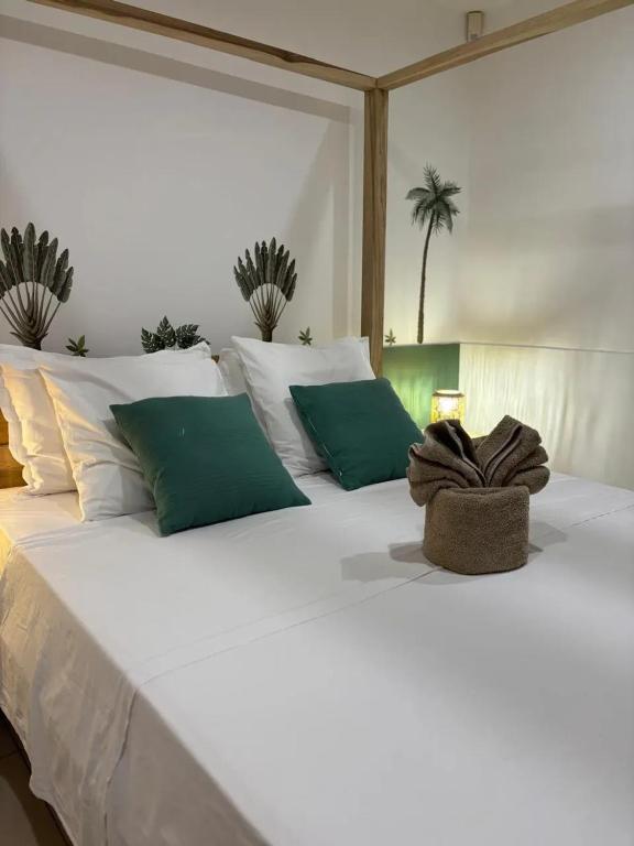 un grande letto bianco con cuscini verdi e bianchi di Villa spacieuse avec piscine à Saint-Pierre a Saint-Pierre