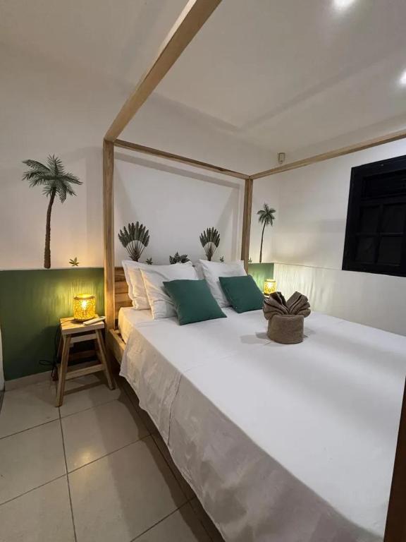 un grande letto bianco in una stanza con palme di Villa spacieuse avec piscine à Saint-Pierre a Saint-Pierre