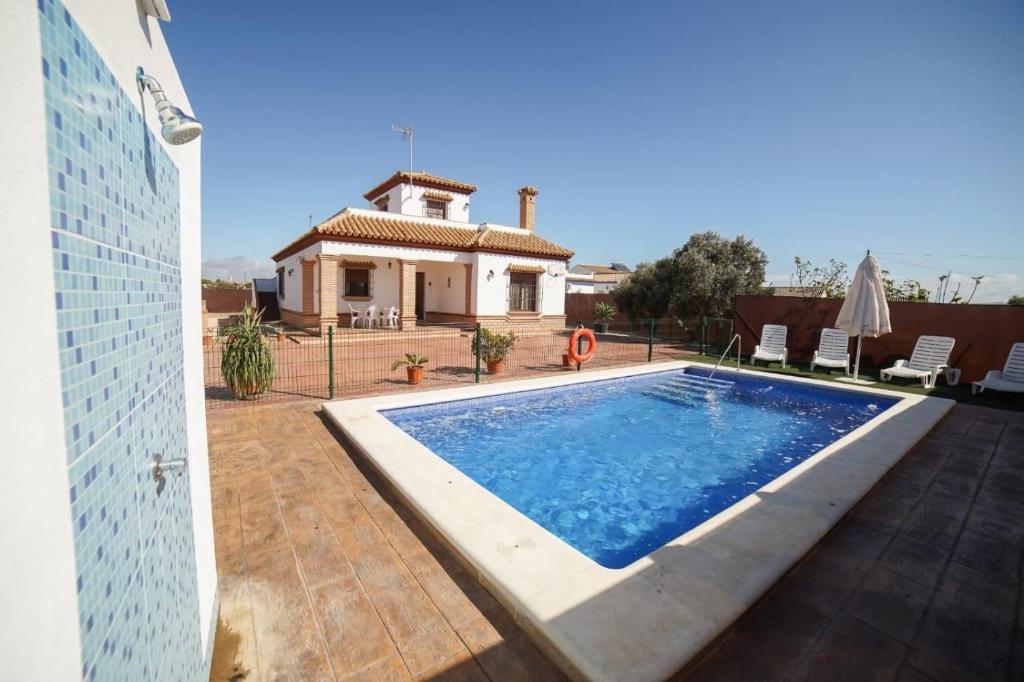 a swimming pool in front of a house at Casa Ana Mari in Conil de la Frontera