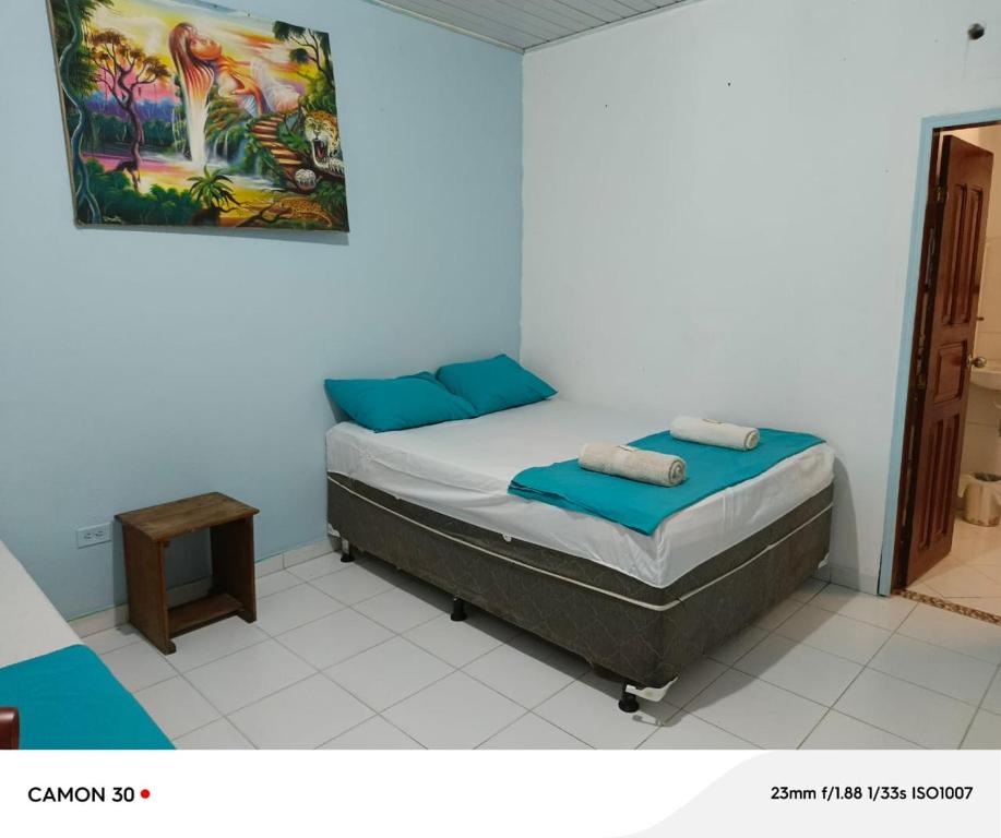 a bedroom with a bed with blue pillows at Alojamiento LETICIA in Leticia