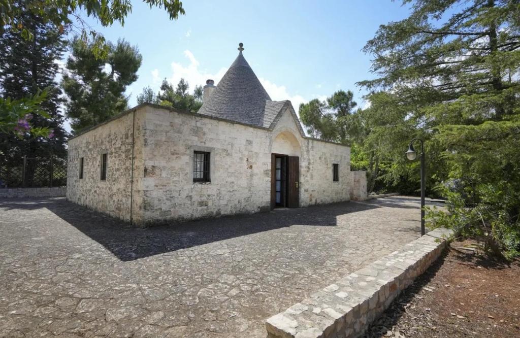 an old stone building with a door in a yard at Il Trullo delle rose, Monopoli by IL PUMO DI PUGLIA in Cozzana