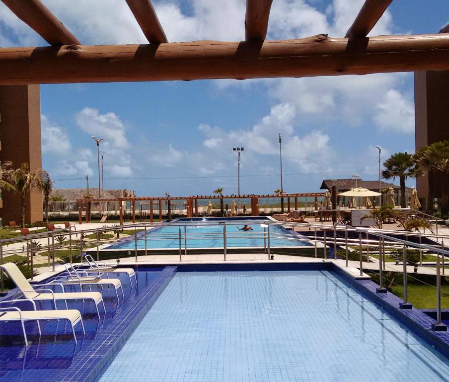 una gran piscina con sillas blancas en VG fun, en Fortaleza