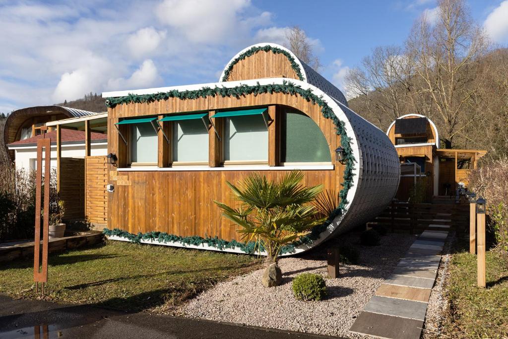 a house with a large circular object on the side of it at L'oasis des Coccinelles - 2 gîtes insolites ultra cosy in Sainte-Croix-aux-Mines