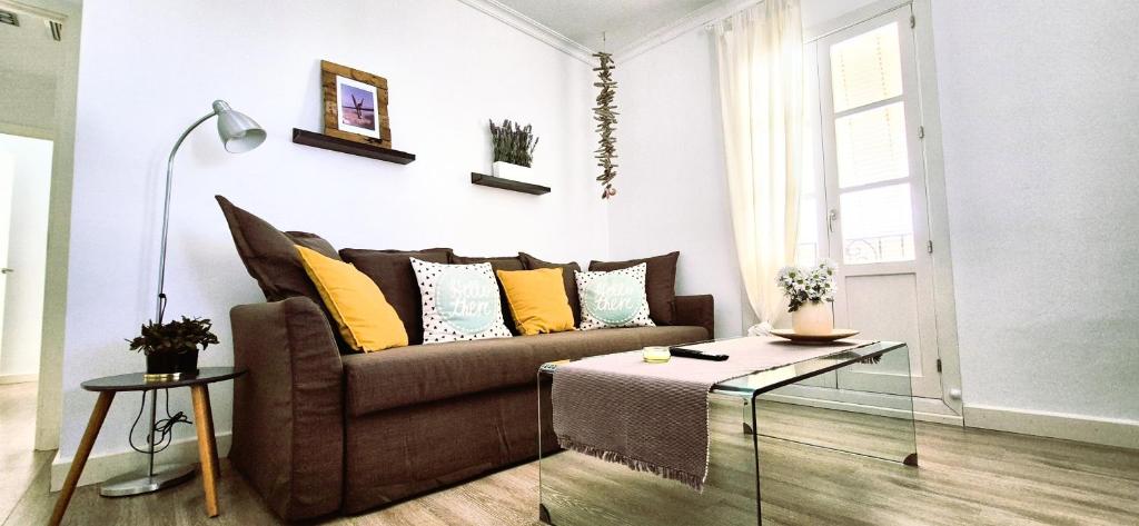 a living room with a couch and a glass table at Sopranis by Gades Gestión in Cádiz