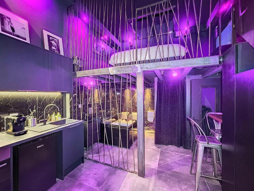 d'une cuisine avec éclairage violet et d'une mezzanine. dans l'établissement Love Room - Dayan 1, à Villeurbanne