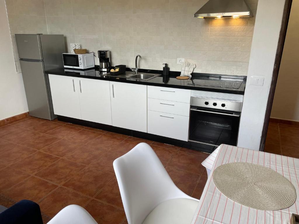 a kitchen with white cabinets and a sink and a stove at Castaño II in Valle Gran Rey