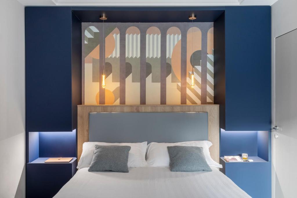 een slaapkamer met een bed met blauwe muren en een schilderij bij Patrizia Romana Palace in Rome