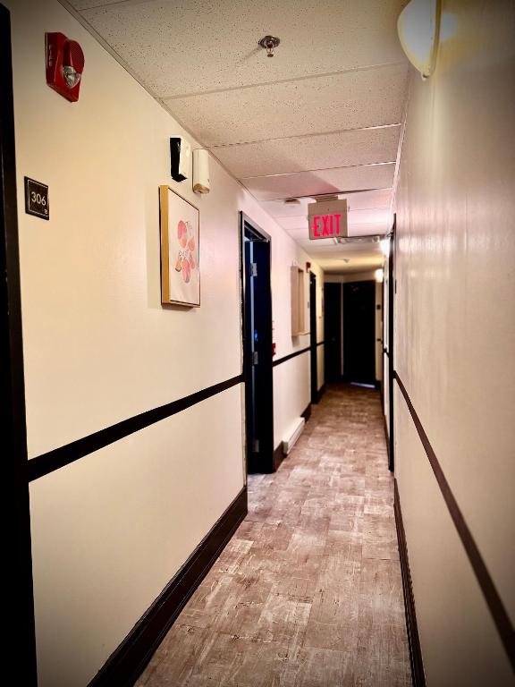 an empty hallway with an exit sign on the wall at Royal Oak Inn in Toronto