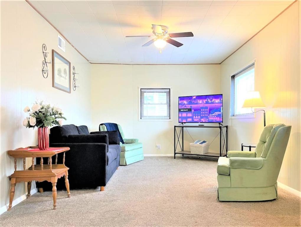 a living room with couches and a flat screen tv at High - Family Neighborhood, Pet Friendly in Van Wert