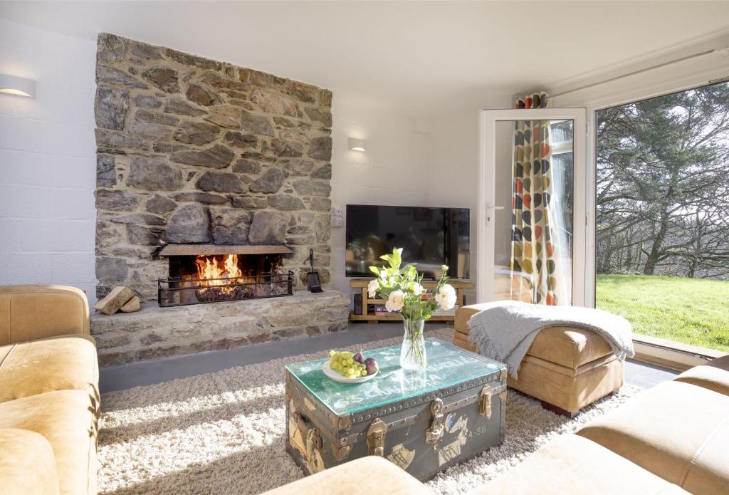 a living room with a large stone fireplace at Fernwood in Totnes