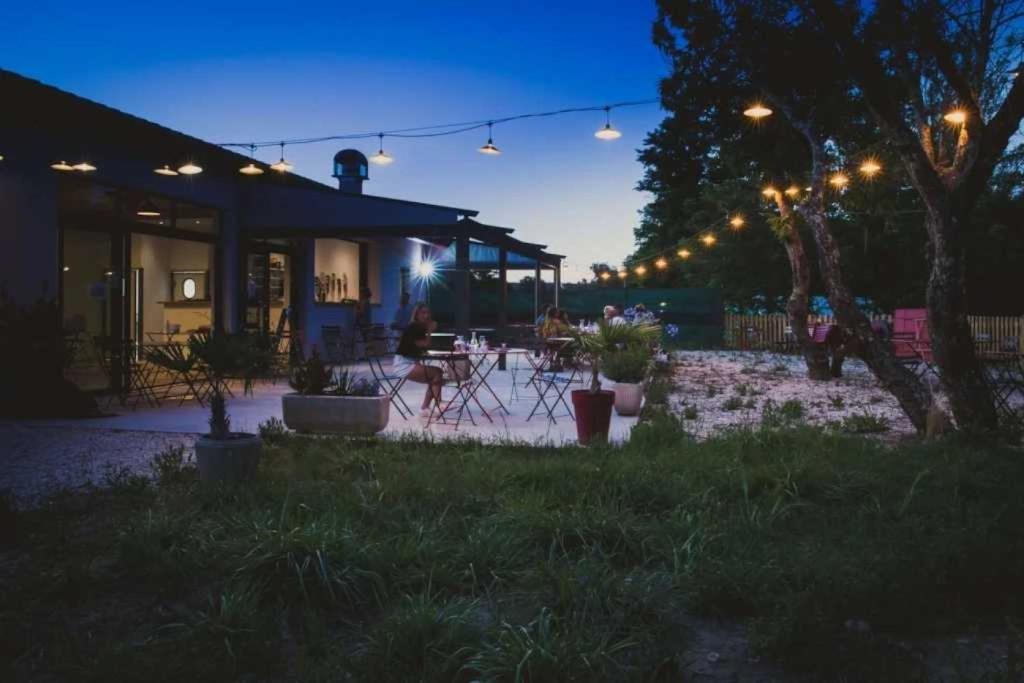 a patio with chairs and lights at night at Camping 3 étoiles - ccaiiah in Ruoms
