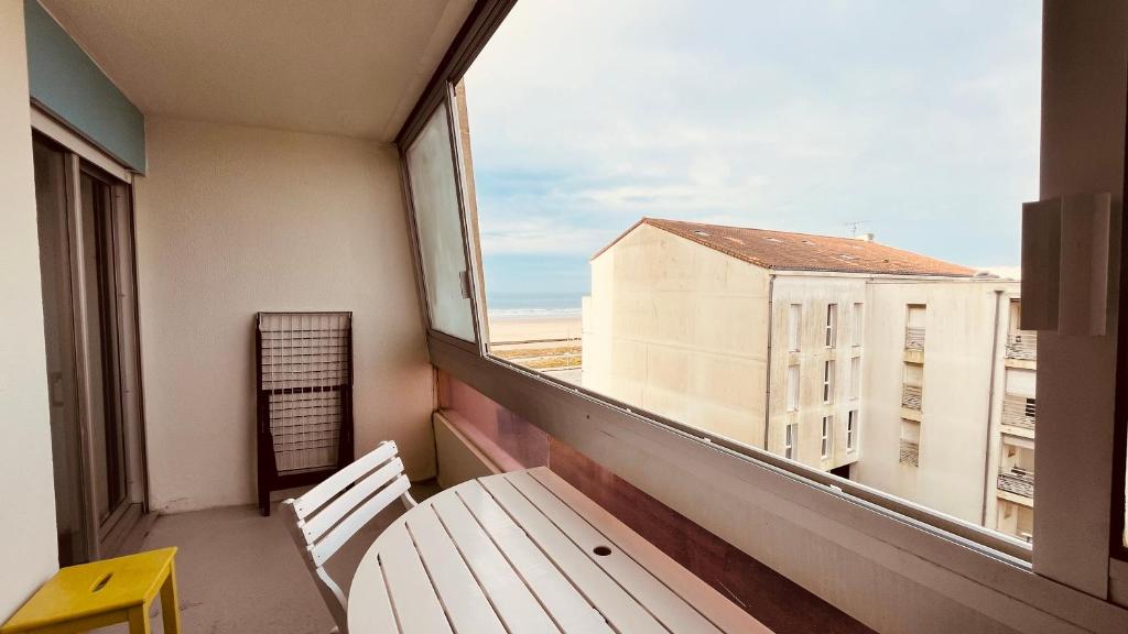 d'un balcon avec un banc et une fenêtre. dans l'établissement Le Saint Hilaire vue océan, à Saint-Hilaire-de-Riez