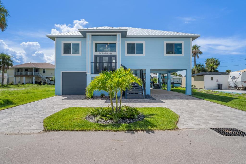 a house with a palm tree in a driveway at Mid Island Beach Getaway - Close to Beach, Heated Pool - Suntide - Roelens in Fort Myers Beach