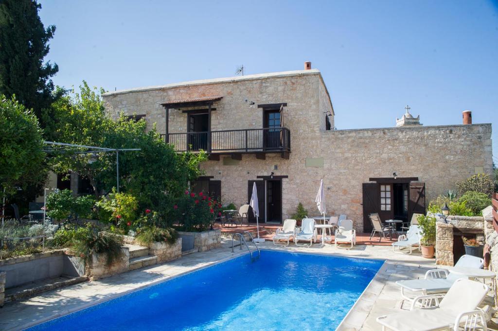 a villa with a swimming pool in front of a building at Sappho Manor House in Droushia