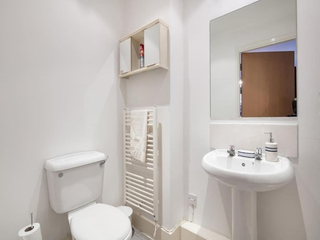 a white bathroom with a toilet and a sink at PNJ Long Stay Central Manchester Accommodation in Manchester