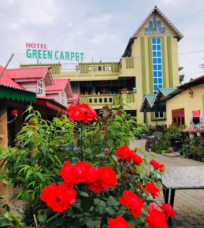 SuryodayaにあるHotel Green Carpetの建物前の赤花群