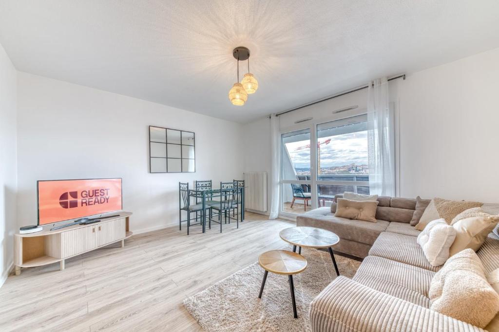 un salon avec un canapé et une télévision dans l'établissement GuestReady - Bright near Parc Tête d’Or, à Villeurbanne