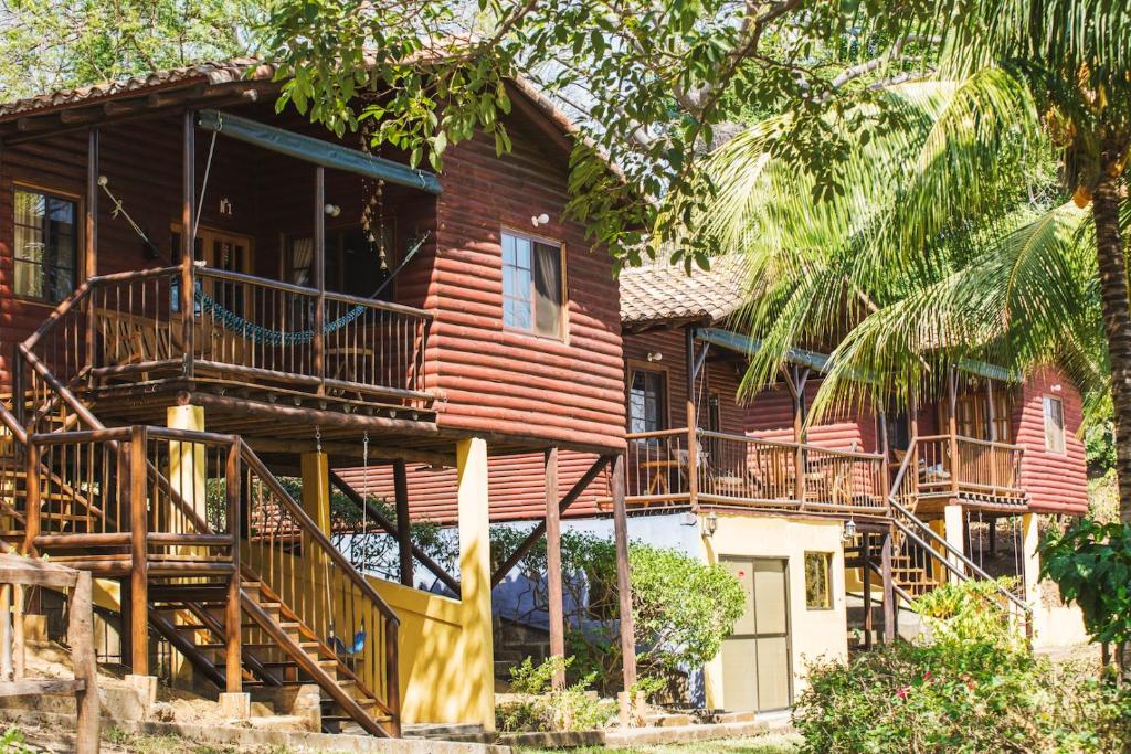 a wooden house with stairs and a balcony at Las Cabañas Encantadas de Nindirí in Nindirí