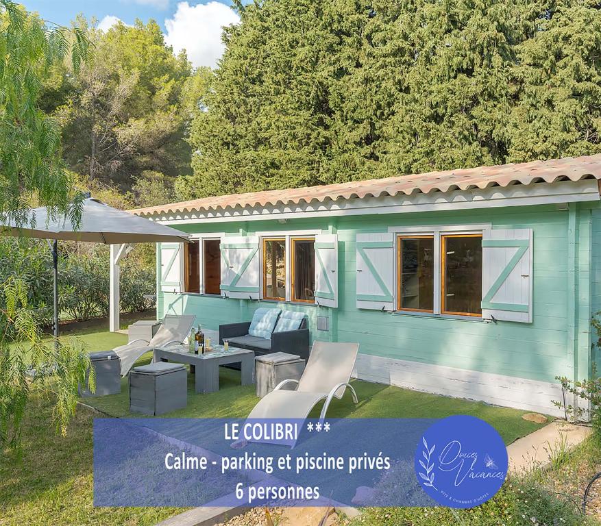 Ce cottage bleu dispose de chaises et d'une table. dans l'établissement "Le Colibri" dans la colline, à La Ciotat