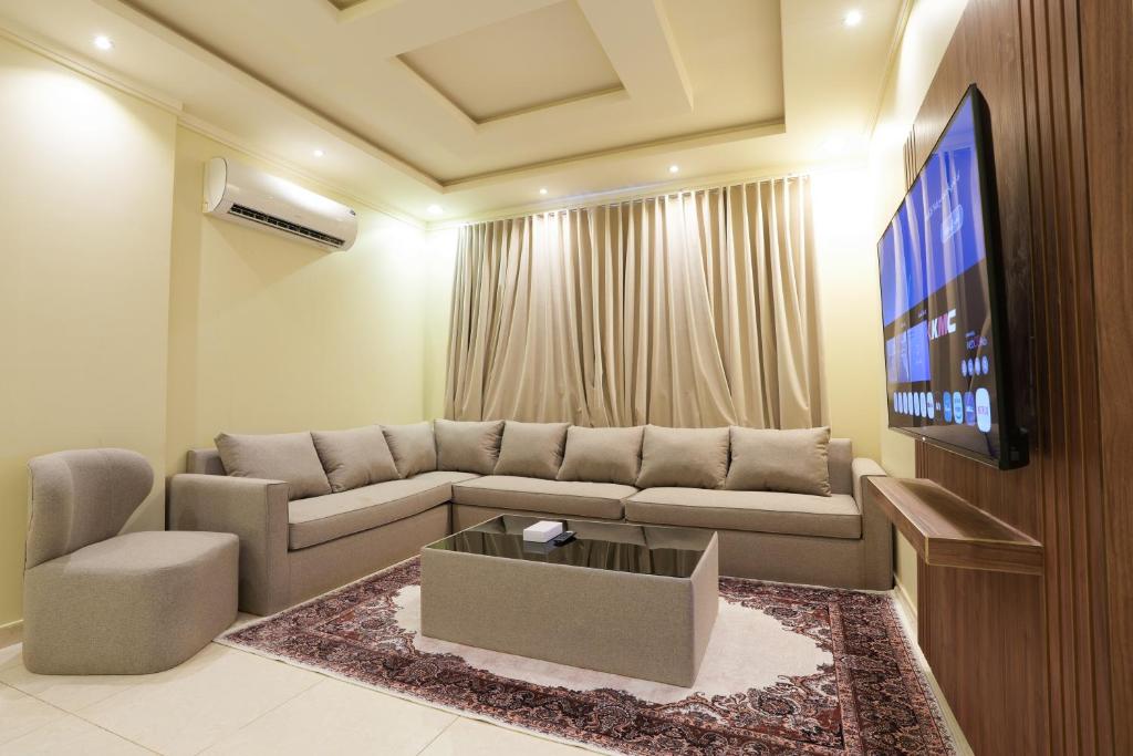 Hotel شقق أركان المربع, a living room with a couch and a tv at شقق أركان المربع in Riyadh