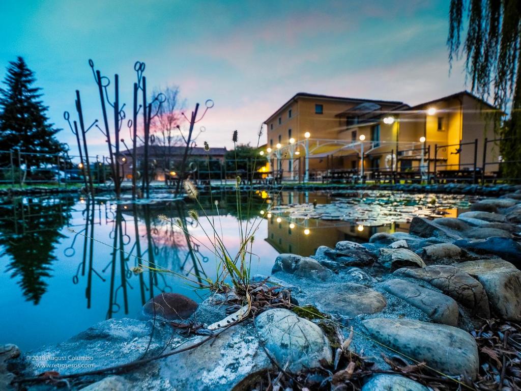 a pond with lilly pads in front of a building at Hotel Villa Costanza in Pontenure