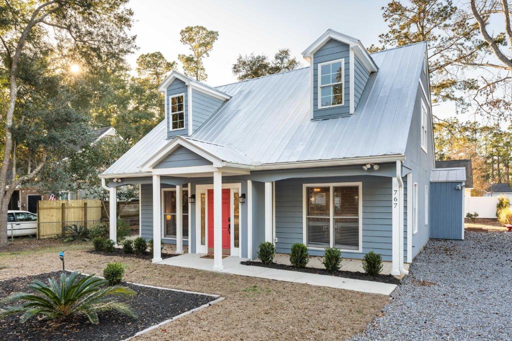 a blue house with a red door at 8-Guest Cozy Escape with Fire Pit & Hot Tub! in Pawleys Island