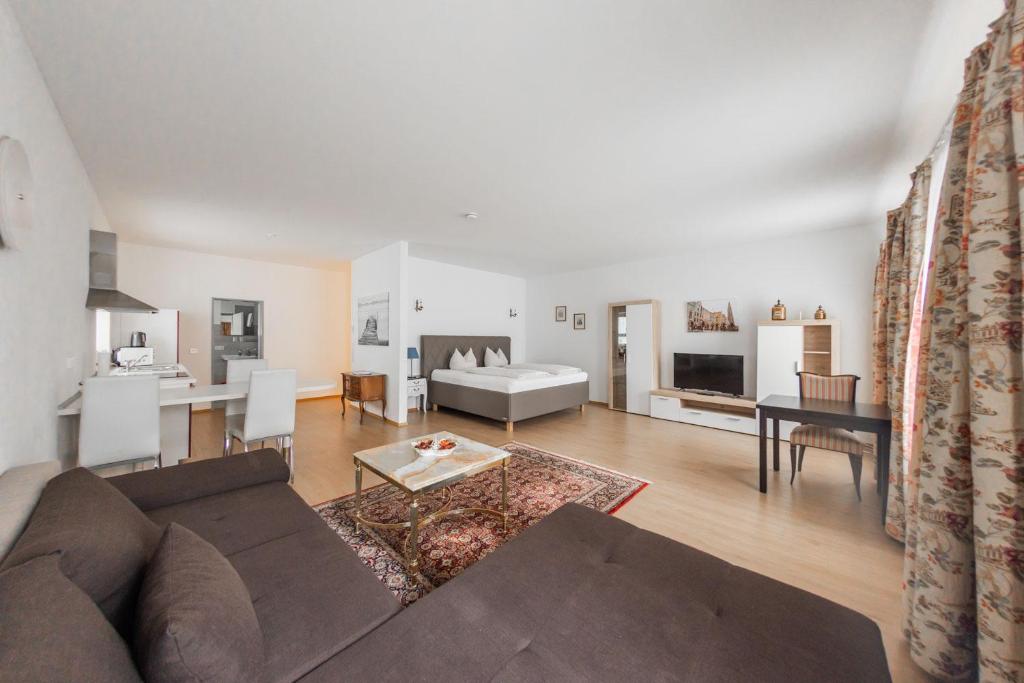 a living room with a couch and a table at Hotel Freischütz Apartments in Landshut