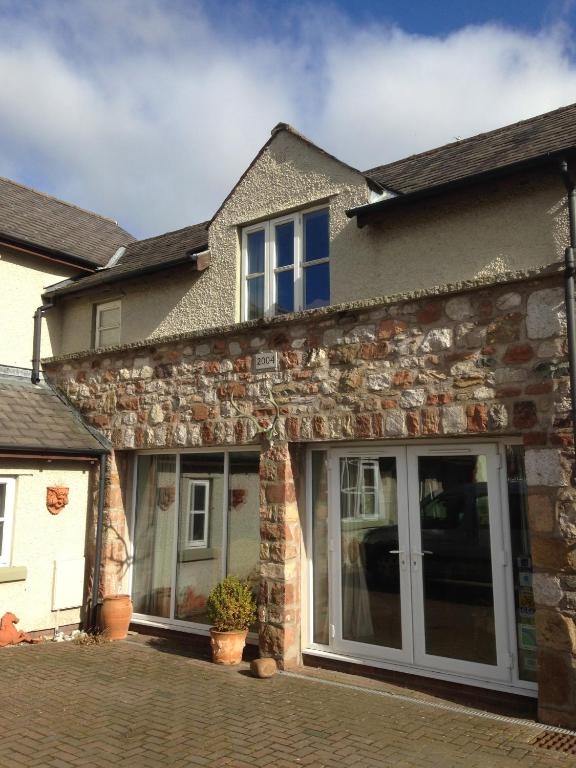 a stone house with sliding glass doors at Rebels Hide -Self check in apartment in Penrith