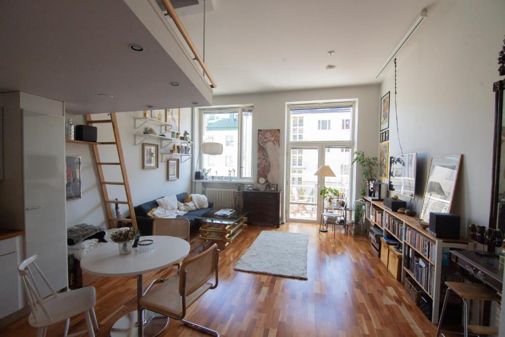a living room with a table and chairs and a living room at Giraffe Loft in Helsinki