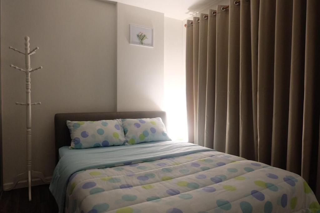 ein Schlafzimmer mit einem Bett mit Kissen und einem Fenster in der Unterkunft nap nap like home 2 in Sathani Khlong Rian