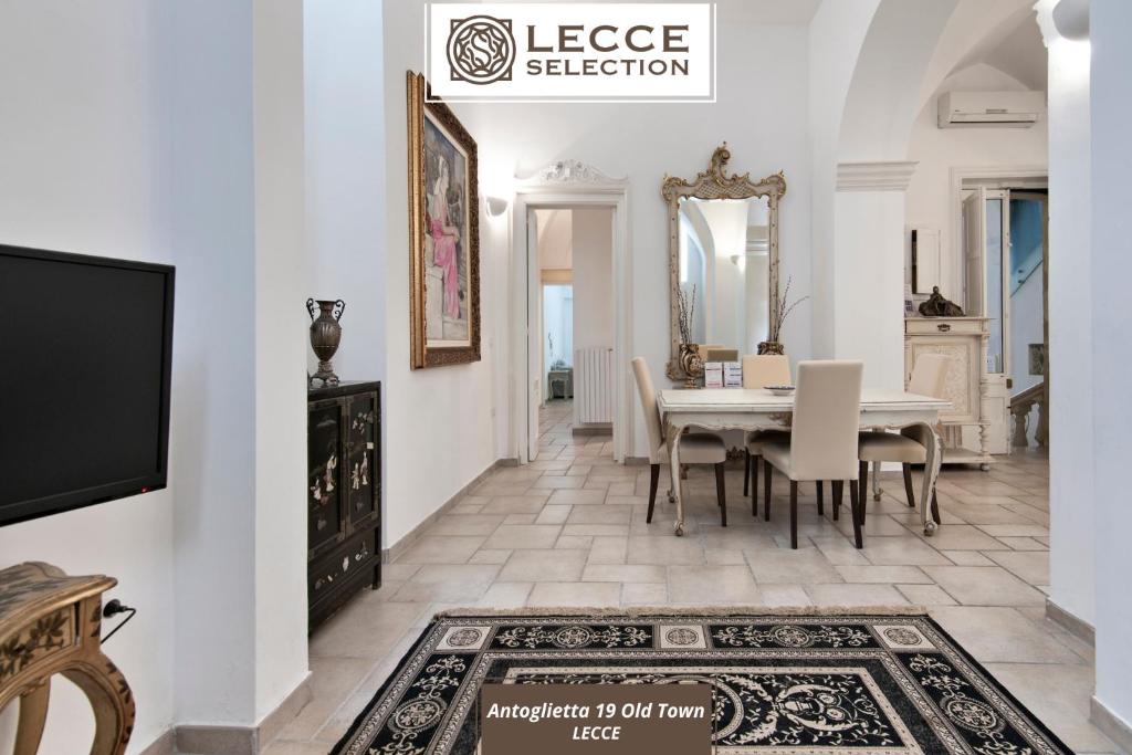a dining room with a table and a tv at Antoglietta 19 Old Town - Lecce Selection in Lecce