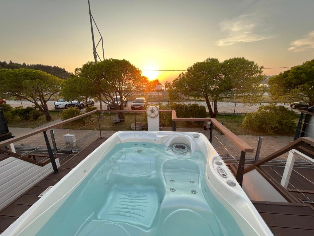 einen Whirlpool auf einer Terrasse mit Blick auf den Sonnenuntergang im Hintergrund in der Unterkunft Marina Luxury Houseboat Lace in Portorož