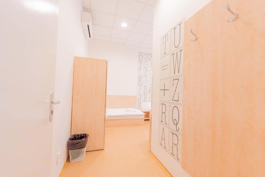 a hallway with a door to a room with a bed at Drunken Monkey Hostel in Prague