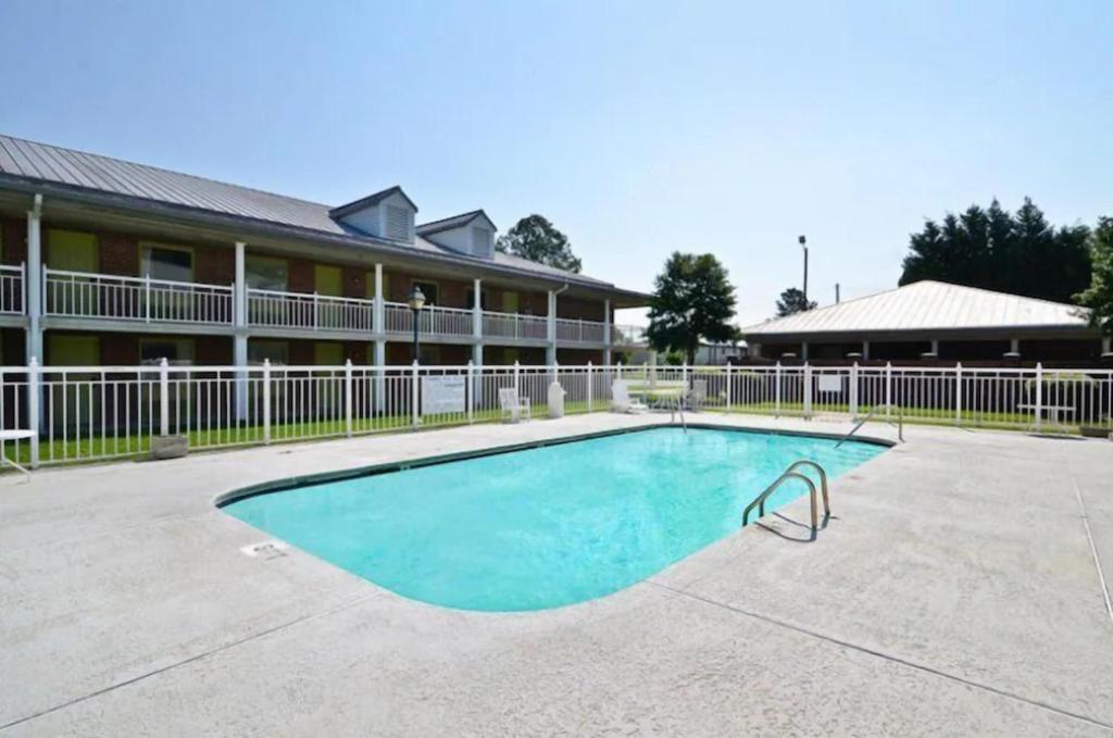 una piscina frente a un edificio en Motel 6 Sandersville, GA, en Sandersville